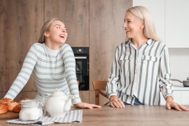 Mutfakta çörekleri olan güzel bir kadın ve annesi.