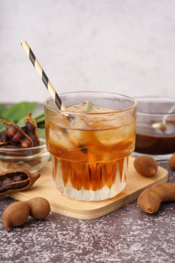 Bir bardak lezzetli demirhindi suyu ve masada meyveler.