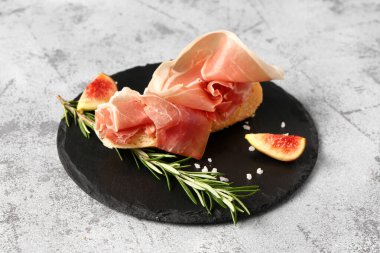 Gri arka planda jambonlu lezzetli sandviç.