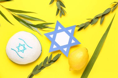 Dört tür (lulav, hadas, arava, etrog) Sukkot festival sembolleri, kippah ve kağıttan David yıldızı olarak sarı arka planda