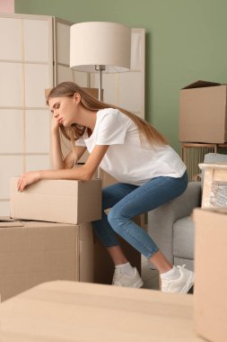 Yeni dairesinde karton kutuları olan güzel genç bir kadın. Taşınma konsepti