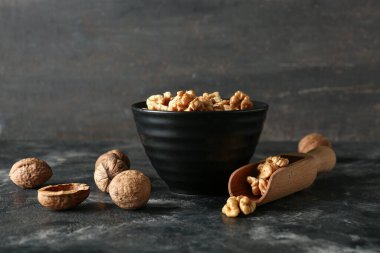 Gri duvara karşı masada bir kase lezzetli ceviz.