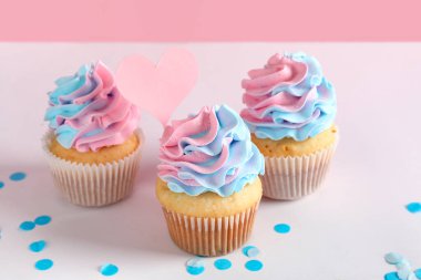 Pembe arka planda konfetisi olan enfes kekler. Cinsiyet ortaya çıkan parti kavramı