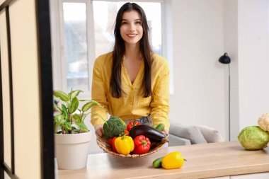 Evde taze sebzeli güzel bir kadın var.