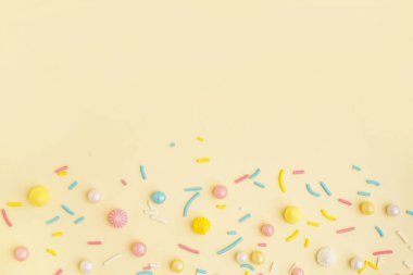 Açık sarı arka planda serpiştirilmiş tatlı renkli serpintiler