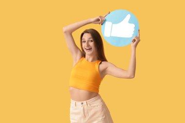 Turuncu arka planda ikon gibi duran güzel genç bir kadın.