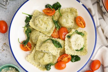 Gri arka planda sebzeli bir kase lezzetli ravioli