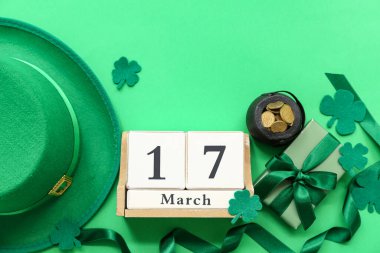 Altın sikkeli çömlek, yeşil arka planda leprikon şapka ve takvim. Aziz Patrick Günü kutlaması