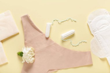 Sarı arka planda tampon ve iç çamaşırlı adet pedleri