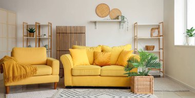 Rahat sarı kanepe, koltuk ve hafif oturma odasında raflar.