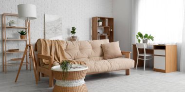 Bej kanepeli, çiçekli ve masalı aydınlık oturma odasının içi.