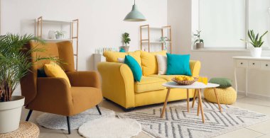 Sarı kanepesi, masası ve koltuğu olan oturma odasının içinde.