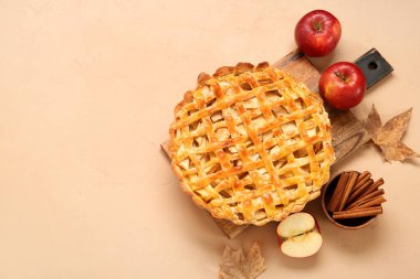 Lezzetli elmalı turta ve turuncu arka planda malzemelerle ahşap tahta.