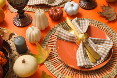 Mumlar ve turuncu arka planda sonbahar dekoru olan şık masa ayarları