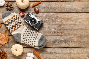 Güzel kompozisyon, kalın çoraplar ve ahşap arka planda fotoğraf makinesi.