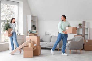 Taşındığı gün odada kutu taşıyan mutlu genç çift.