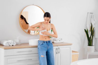 Güzel genç bayan banyoda göğüslerini kontrol ediyor. Kanser farkındalığı kavramı