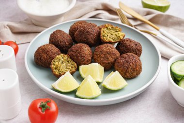Nefis falafel köfteli tabak, arka planda limon ve domates, yakın plan.