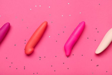 Pembe arka planda seks dükkanından farklı vibratörler içeren kompozisyon