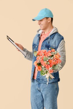 Çiçek buketi ve bej arka planda panosu olan erkek kurye.