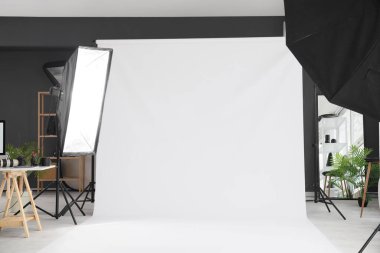 Profesyonel ekipmanı ve beyaz arkaplanı olan modern fotoğraf stüdyosunun içi