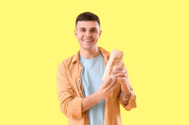 Sarı arka planda lezzetli donör kebabı olan yakışıklı genç adam.