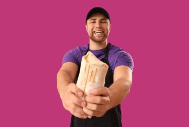 Mor arka planda lezzetli donör kebabı olan aşçı