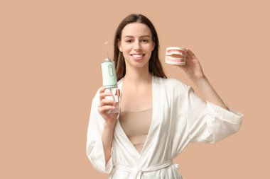 Kahverengi arka planda ağız sulandırıcısı ve çene modeli olan güzel genç bir kadın.