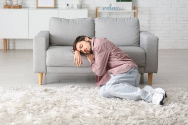 Evdeki kanepede uyuyan yorgun genç adam.