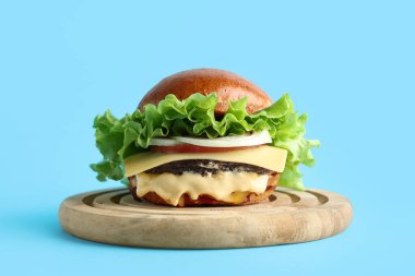 Mavi arka planda lezzetli burgerli ahşap tahta.