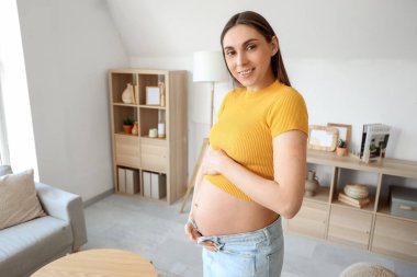 Evde aşıdan sonra yamayla gezen hamile bir kadın.