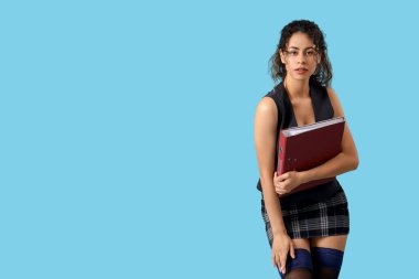 Mavi arka planda klasörü olan çekici Afro-Amerikan sekreter.