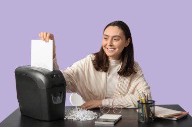 Sekreter, Leylak arkaplanındaki belgeyi imha ediyor.