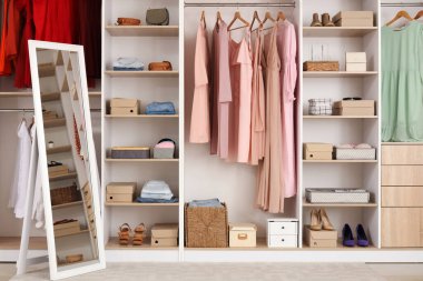 Soyunma odasında farklı kıyafetleri ve aksesuarları olan büyük gardırop.