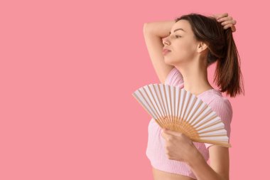 Pembe arka planda beyaz elli güzel bir kadın.