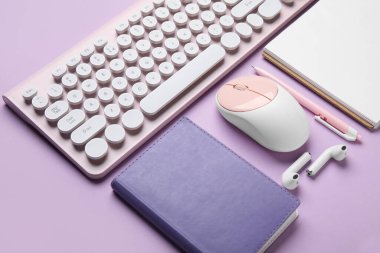 PC klavye, fare, kulaklık ve eflatun arkaplan üzerine kırtasiye