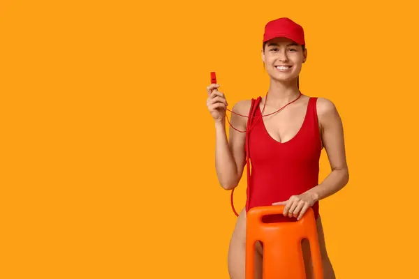 stock image Female lifeguard with rescue tube buoy and whistle on yellow background