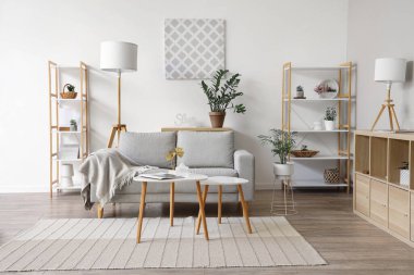 Kanepe, ekose, raf ünitesi ve sehpası olan bir oturma odası.