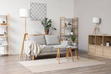 Kanepe, ekose, raf ünitesi ve sehpası olan bir oturma odası.