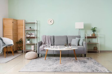 Oturma odasının içinde kanepe, ekose ve sehpa var.