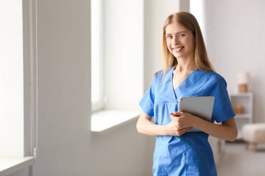 Evde tableti olan bir kadın stajyer.