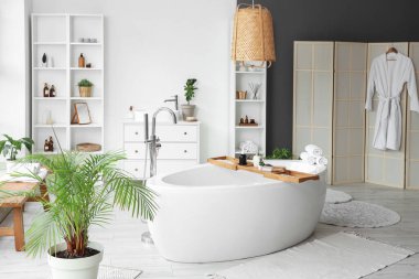 Küveti, raf ünitesi ve lavabosu olan şık bir banyo.