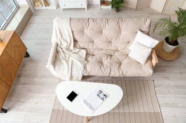 Yumuşak kanepesi, çekmecesi ve sehpası olan modern oturma odası.