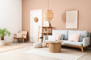 Rahat kanepesi, sehpası, dizüstü bilgisayarı ve resmi olan modern oturma odası.