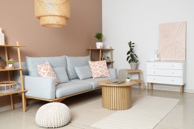 Rahat kanepesi, sehpası, dizüstü bilgisayarı ve resmi olan modern oturma odası.