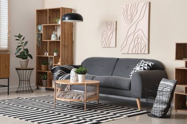 Rahat kanepesi, sehpası, lambası ve resimleri olan şık bir oturma odası.