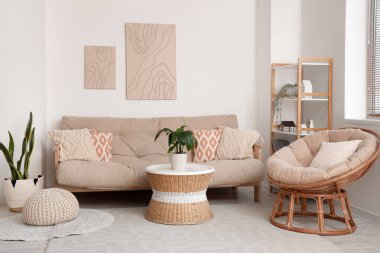 Rahat kanepesi, sehpası, çiçekleri, koltuğu ve resimleri olan modern oturma odası.