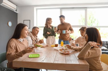 İş arkadaşları ofis mutfağında yemek yiyor.