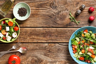 Tahta arka planda turplu ve peynirli taze sebze salatası.