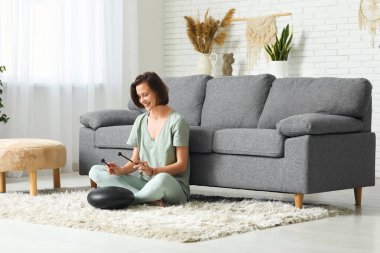 Genç bir kadın evde glukofon çalıyor.